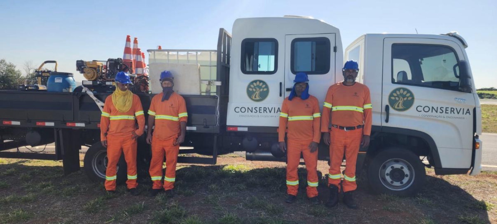 Equipe própria da Conservia uniformizada diante do caminhão de apoio